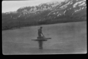 Image of Man in water with pole/equipment